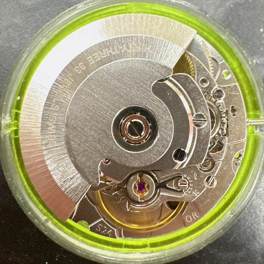 Close-up of China Made 2824 automatic mechanical watch movement with small second hand, precision timekeeping.