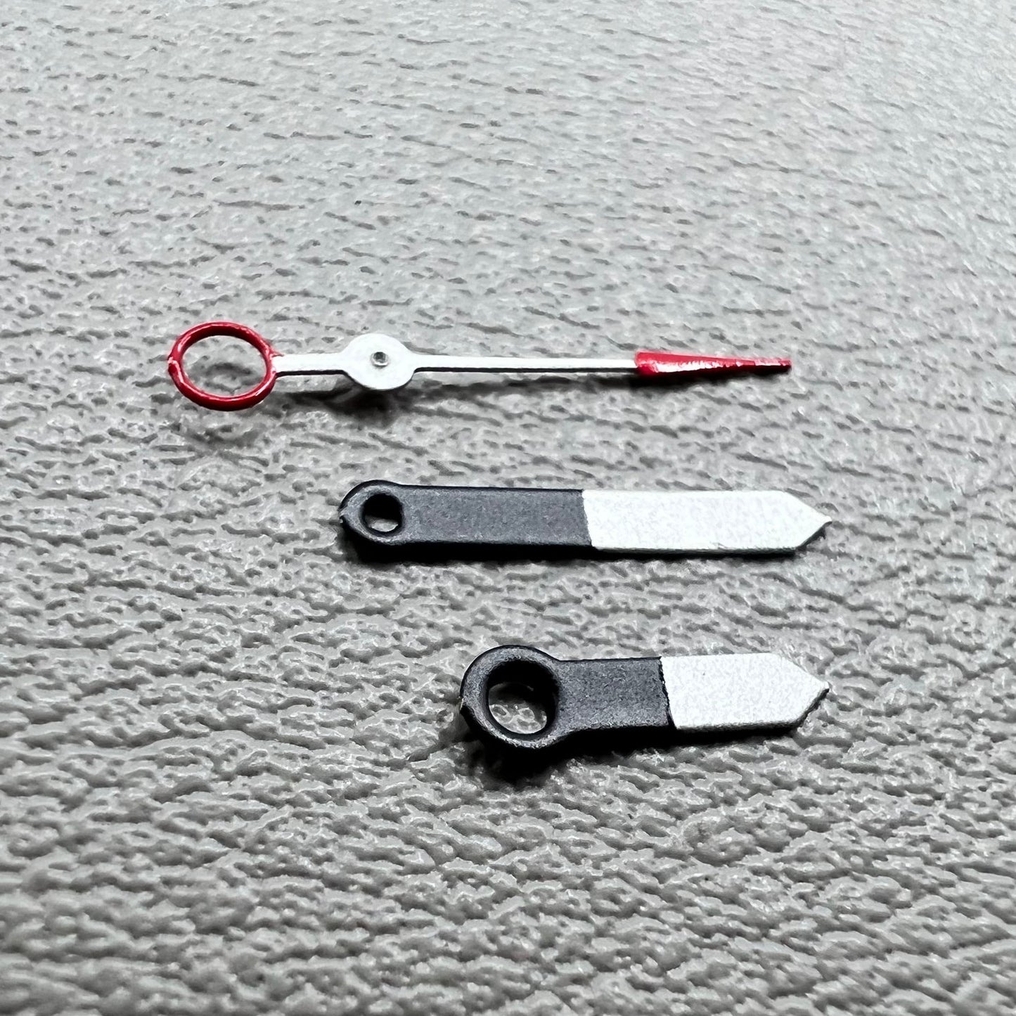 Set of black and white painted trim arrow-shaped watch hands without lume for Ronda 515, ideal for precise timekeeping.