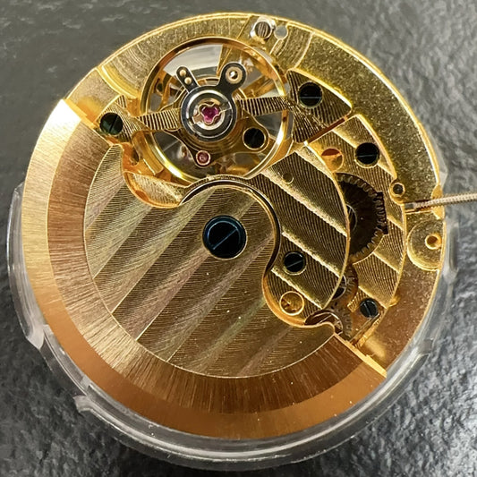Golden mechanical movement watch repair part featuring moon phase at 12 o'clock and visible flywheel, China made.