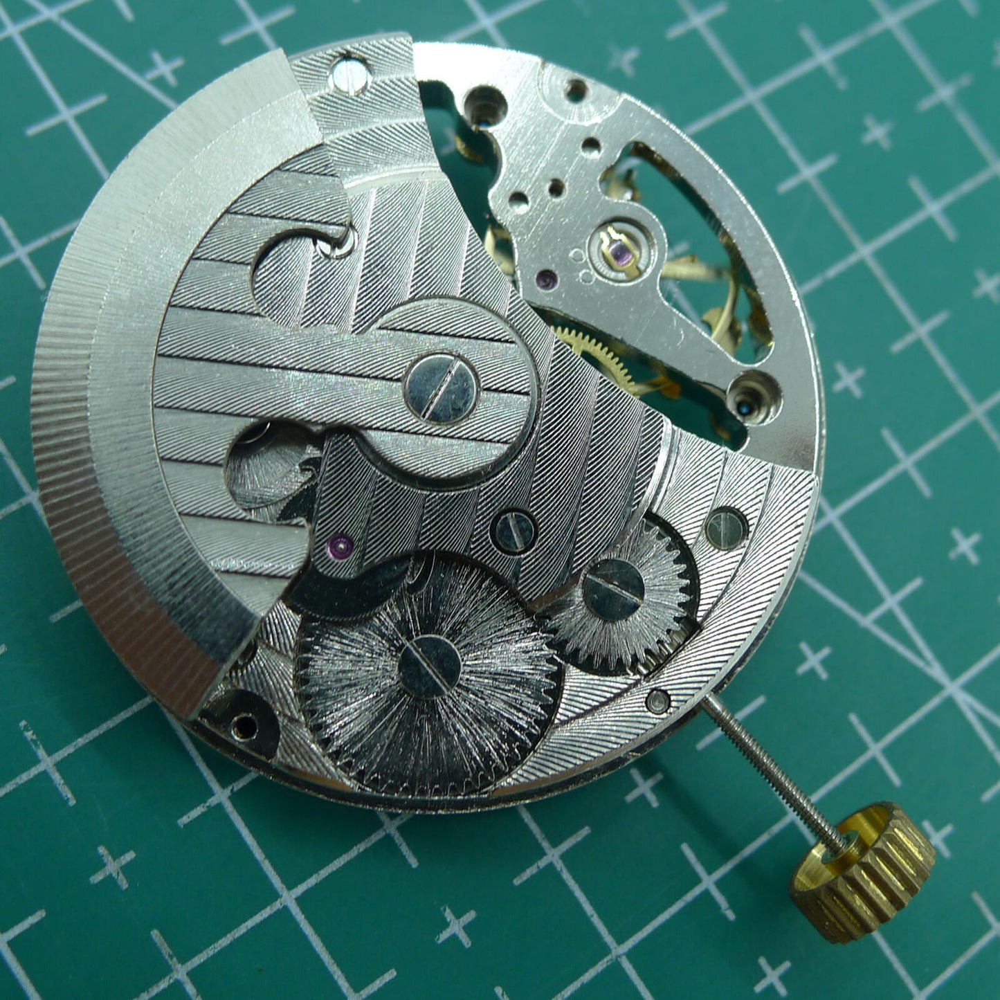 Silver automatic mechanical watch featuring hollow moon phase at 12 o'clock, elegant design.