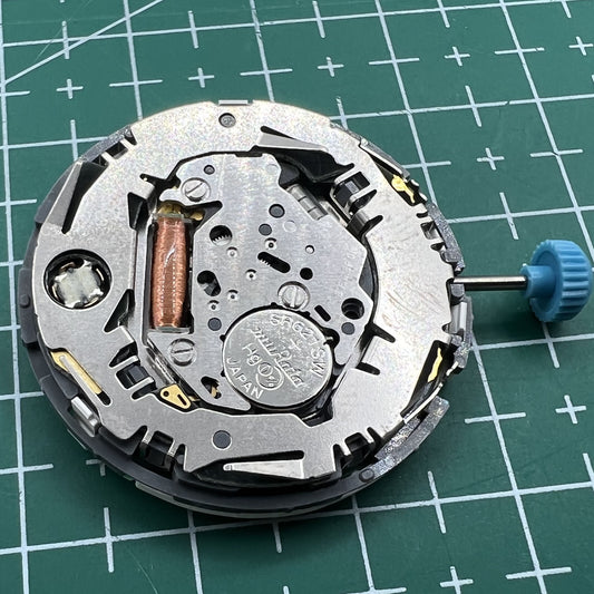 Miyota 6N10 quartz watch movement with luminescent hands and single calendar date at 3 o'clock.