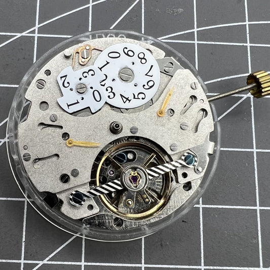 Automatic mechanical watch with reversed balance wheel and big date at 12, precision timepiece.