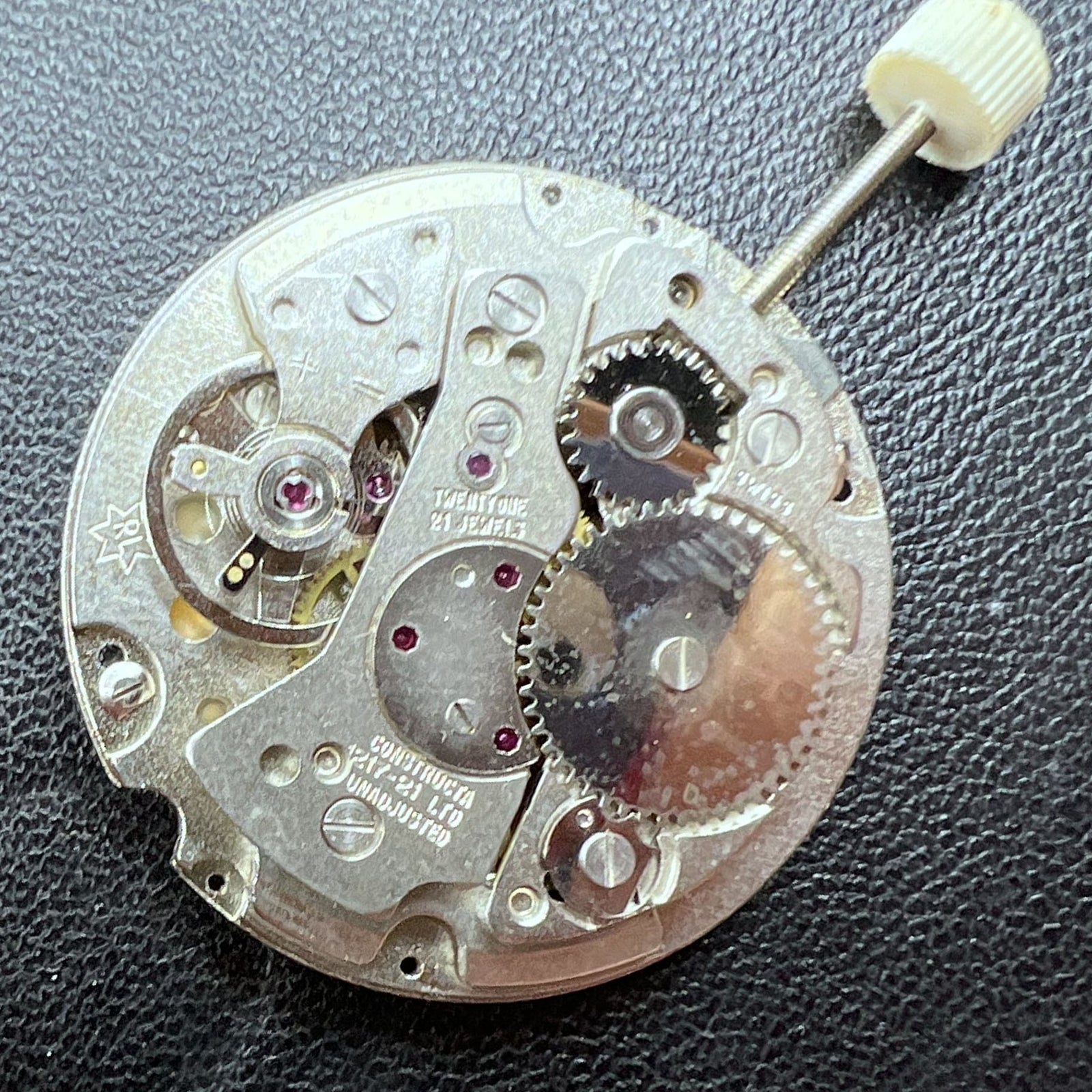 Disassembled Swiss RONDA MATIC 1217-21 manual winding watch movement showing intricate repair details.