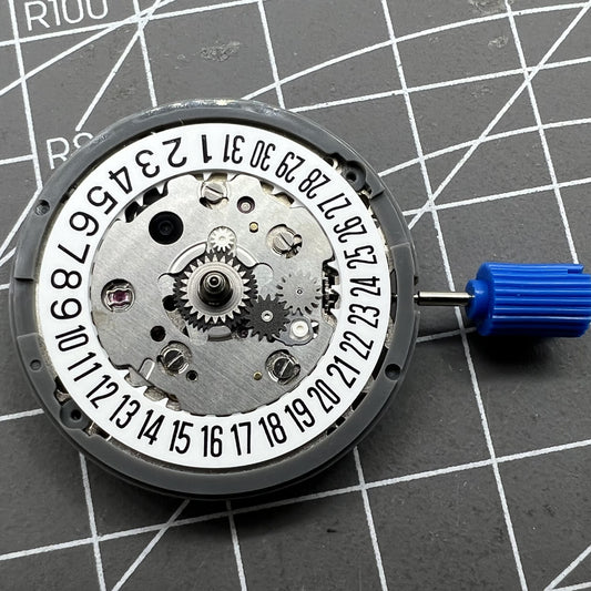 NH34 automatic mechanical GMT watch movement with hacking seconds and date at 6, featuring a white disk wheel.
