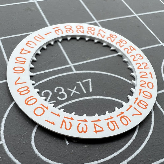 Close-up of NH35 watch date wheel featuring orange font on white background for precise timekeeping.