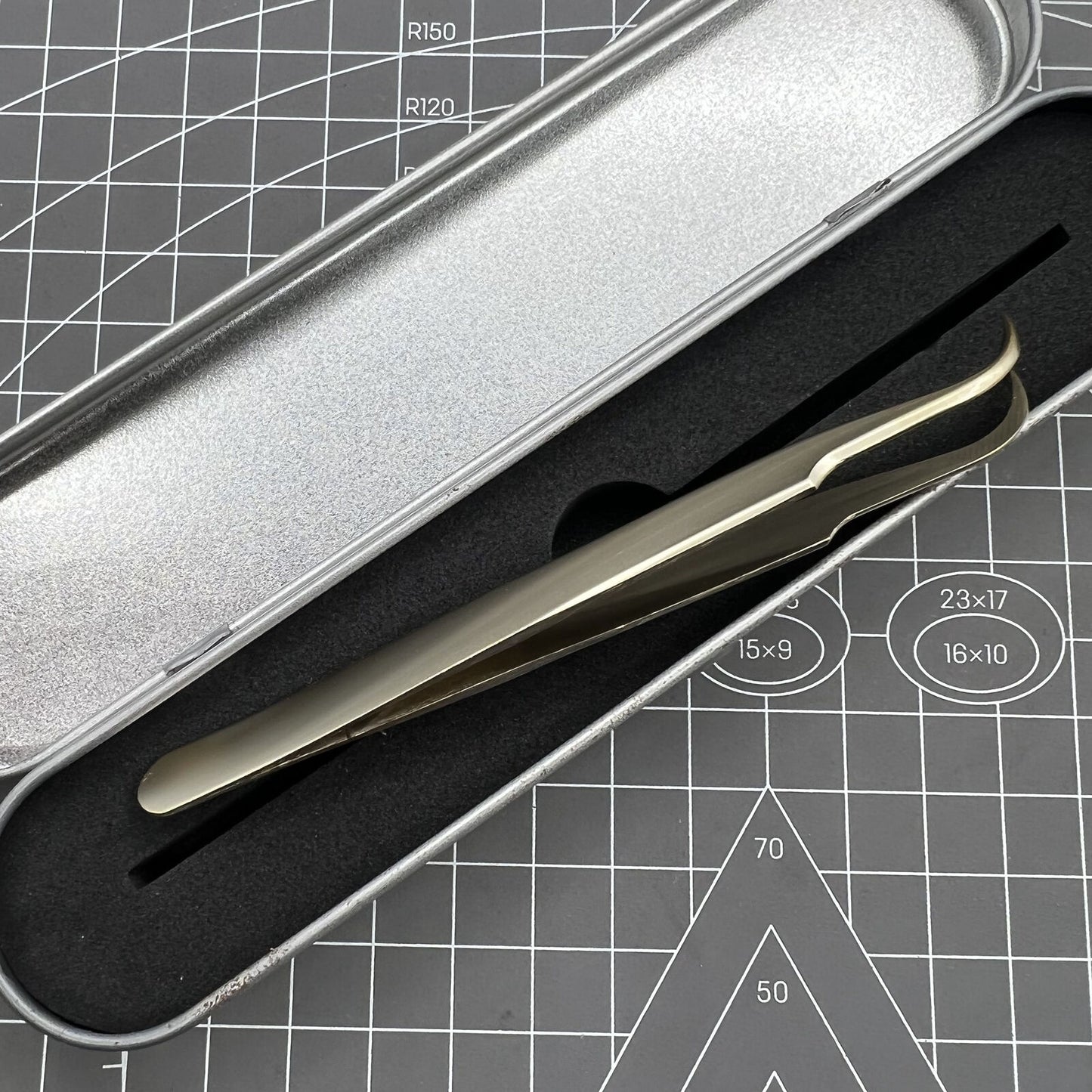 Golden curved elbow stainless steel tweezers for precise watch accessory handling.