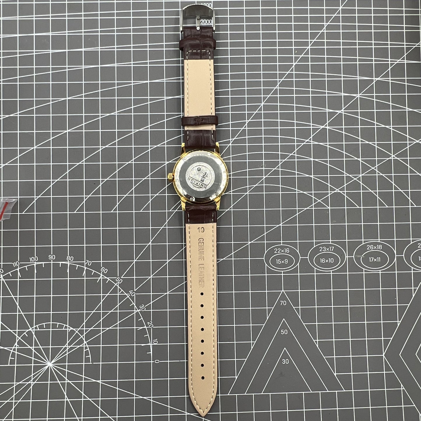 Beijing Double Rhomb manual watch, gold case with silver nail markers, classic vintage style accessory.