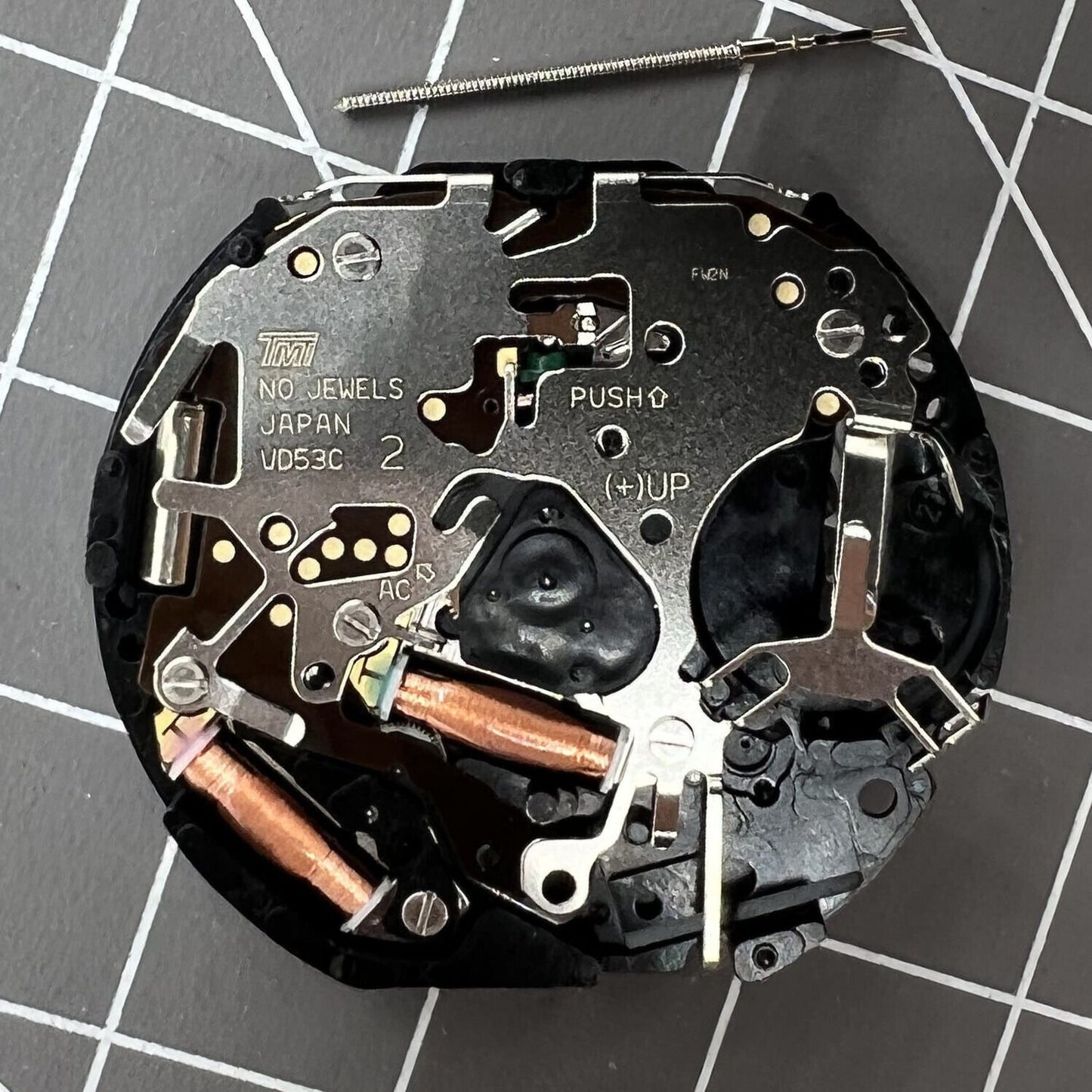 Japan Made Hattori Epson TMI VD53 quartz watch movement showing date display at 3, 6, and 4:30 positions for precise timekeeping.