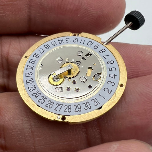 Swiss Made Ronda 1006 Slimtech golden quartz watch movement with date display at 6 o'clock, precision timekeeping part.