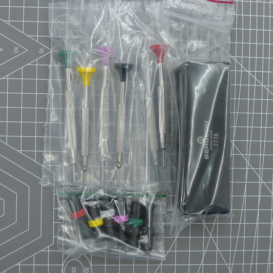 Swiss Bergeon 7778 screwdriver set with 6 precision tips, spare blades, and sturdy stand for watch repair.