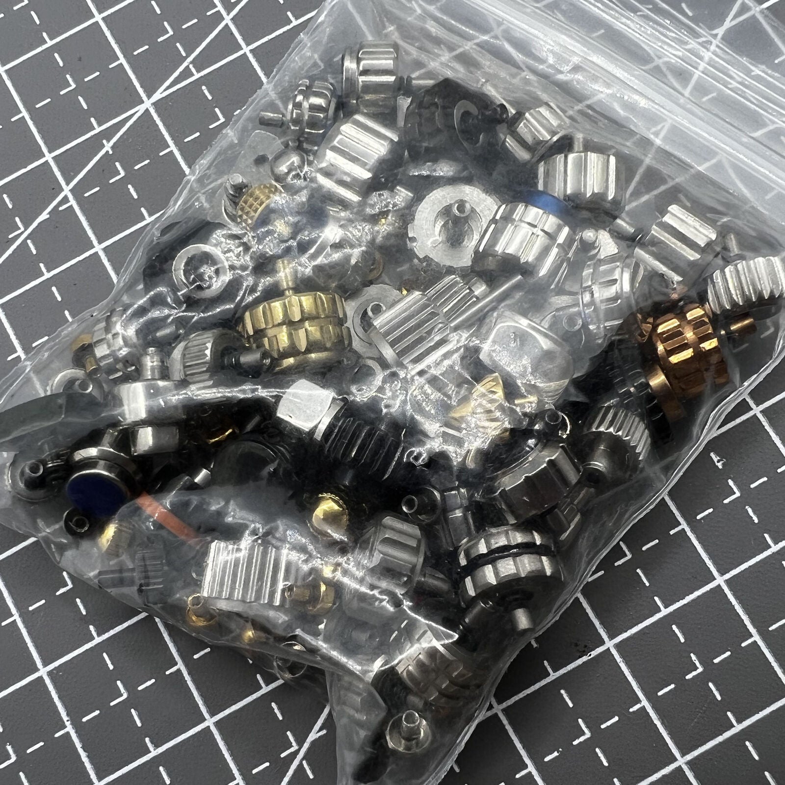 Variety of 100 watch crowns in various sizes for precise watch repair and replacement with durable quality.