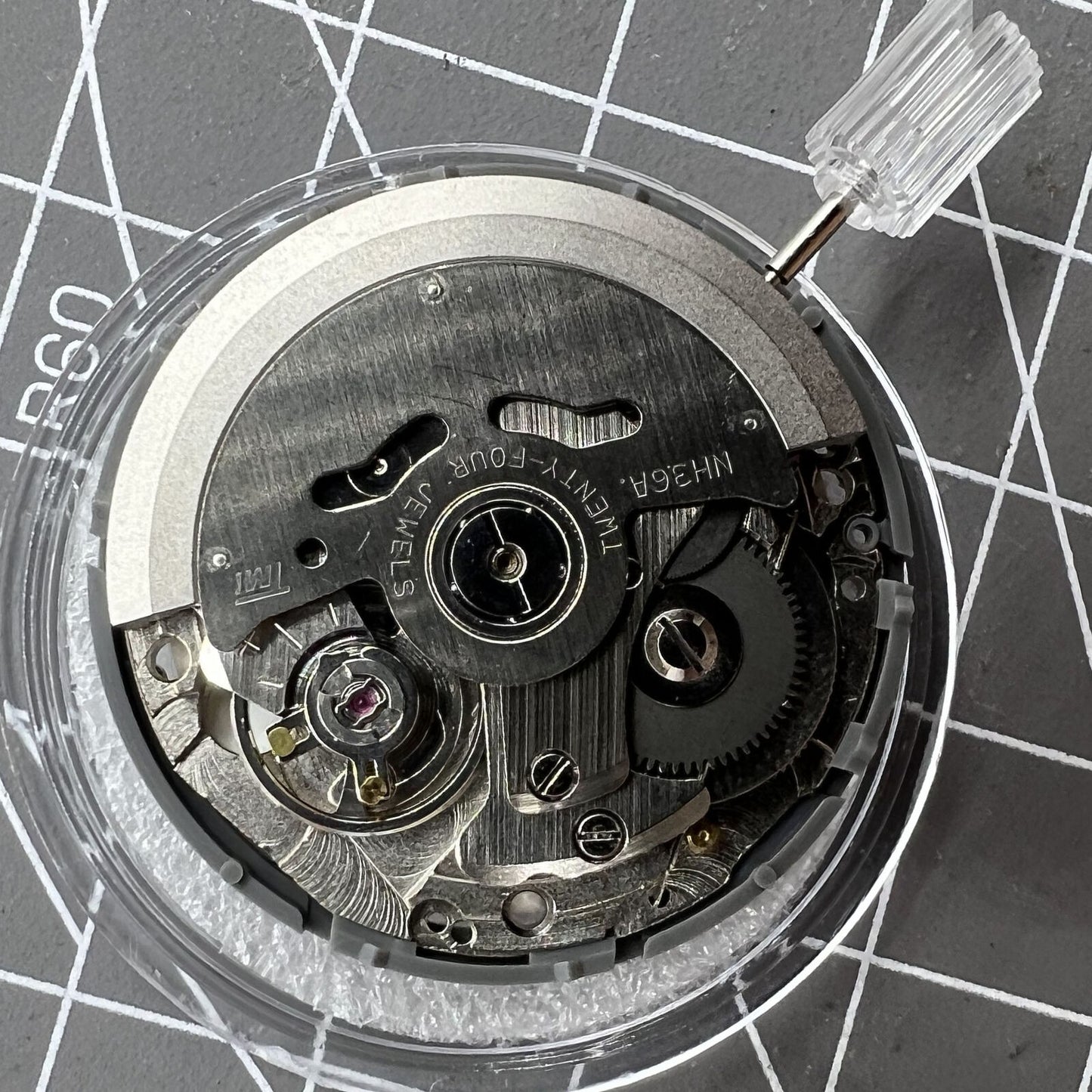 Miyota NH36A watch movement with white dial and blue luminescent markers, featuring precise 3/3.8 crown placement.