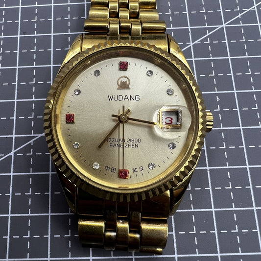 Golden dial 38mm Wudang Steel watch with single calendar, manual mechanical movement, 17 jewels, elegant design.