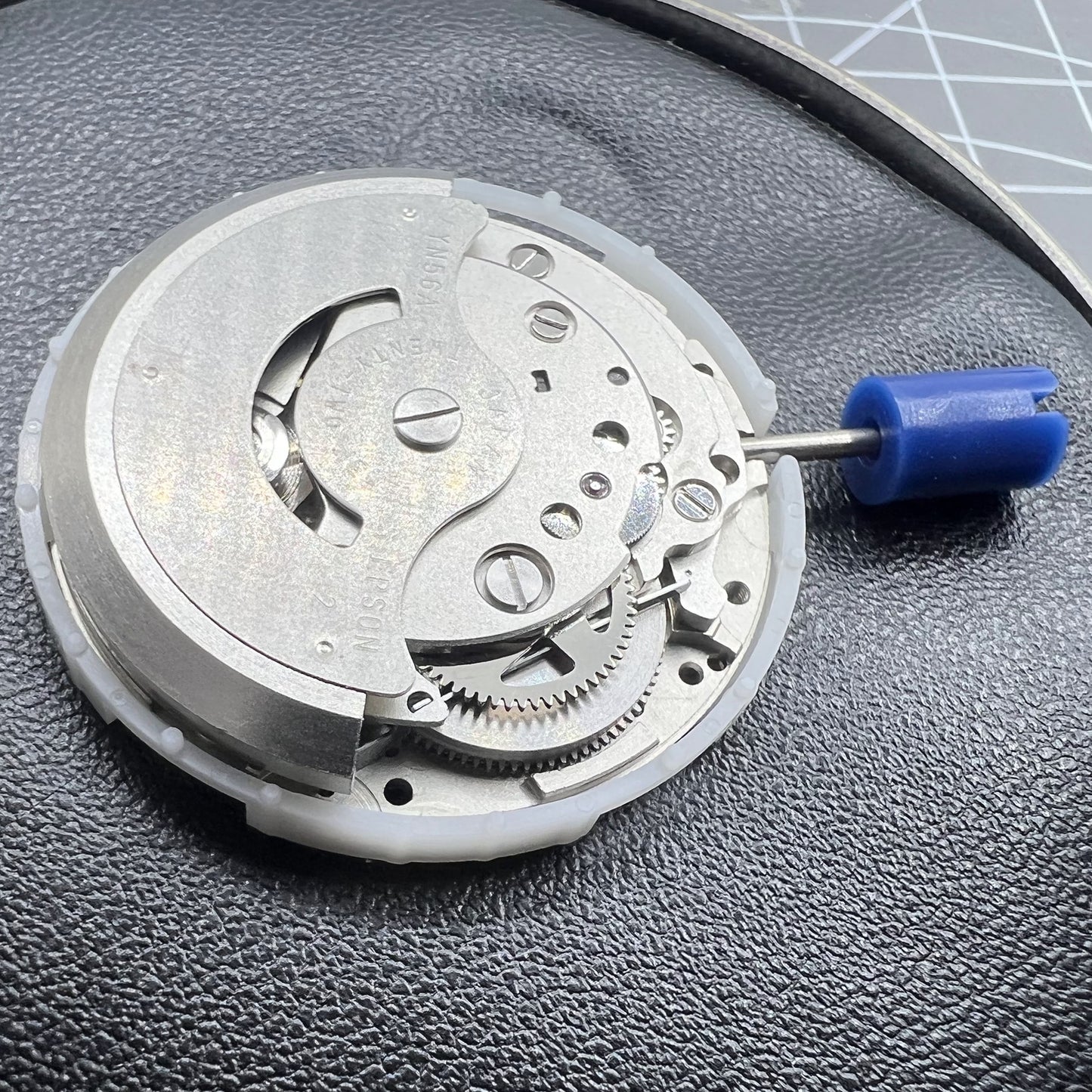 Close-up of Japan Epson YN56 mechanical watch movement with visible date and day display for repair.