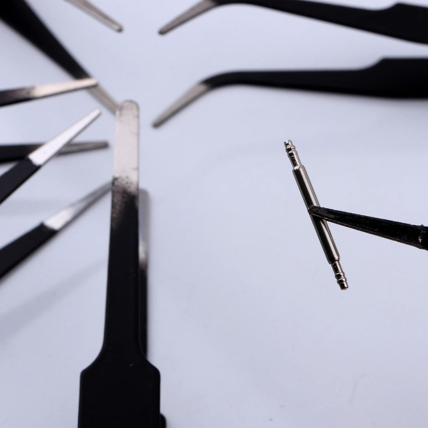 Set of 6 black-plated anti-static stainless steel tweezers in PVC bag for precise watch and jewelry repair.