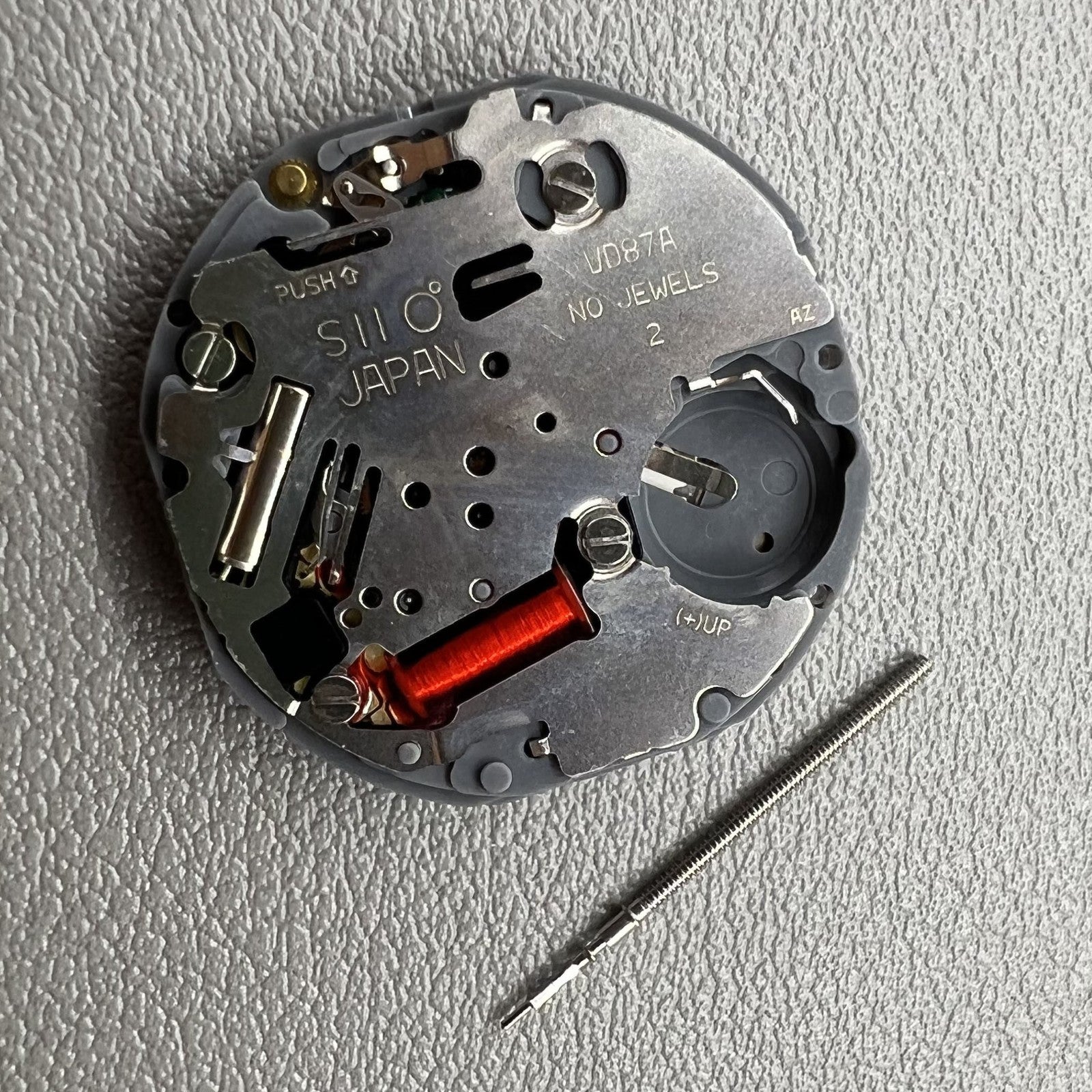 Close-up of Japan Hattori Epson VD87A quartz watch movement for precise timekeeping.