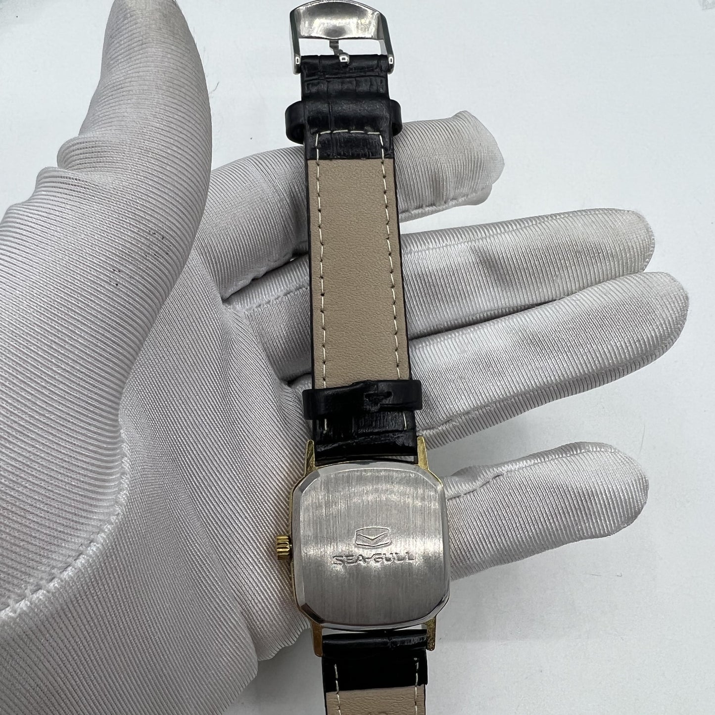 Seagull 28mm ladies watch featuring a golden square case and manual mechanical movement, elegant style.