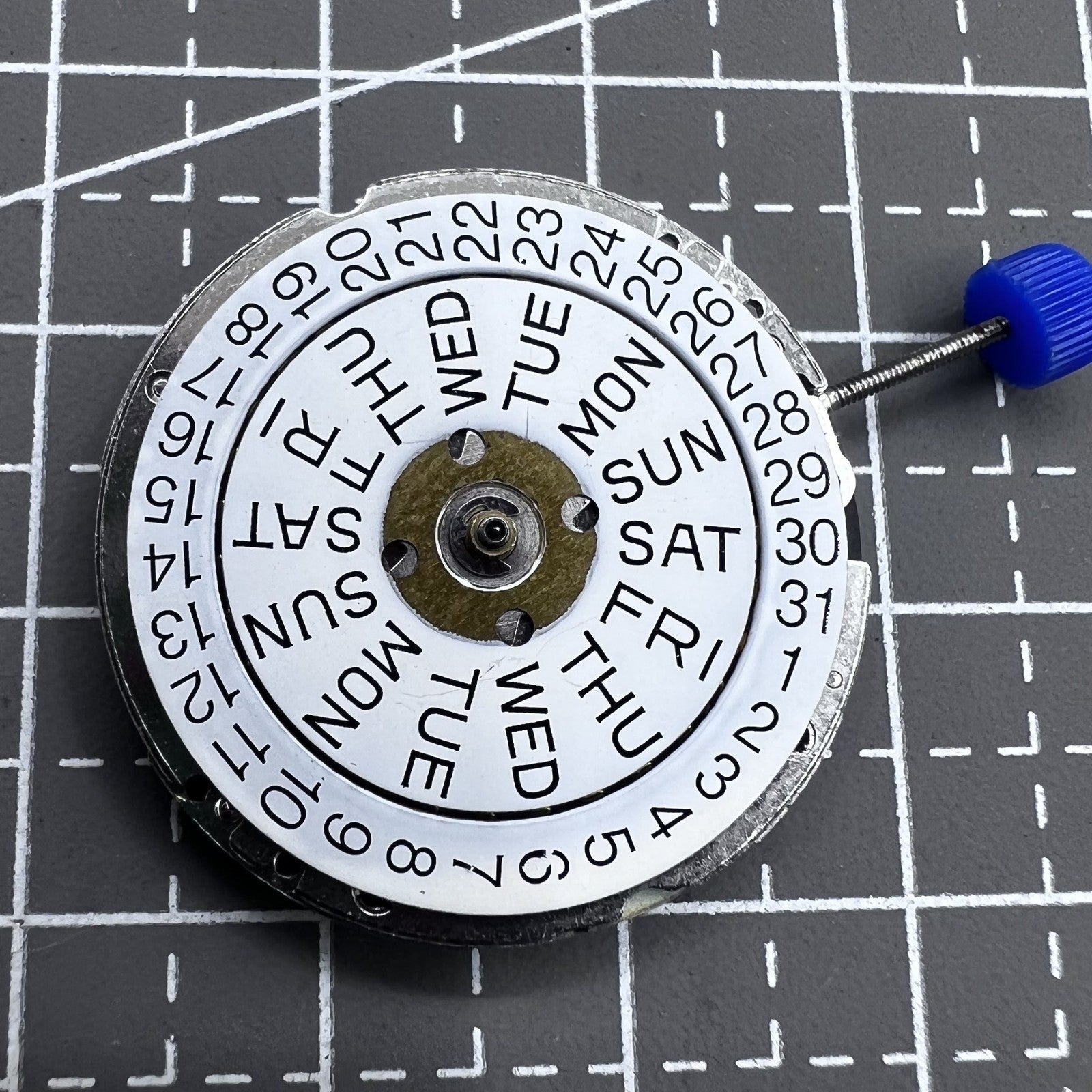 Swiss ISA 1198 Quartz watch movement with 3 hands, English day-date display for precision timekeeping.