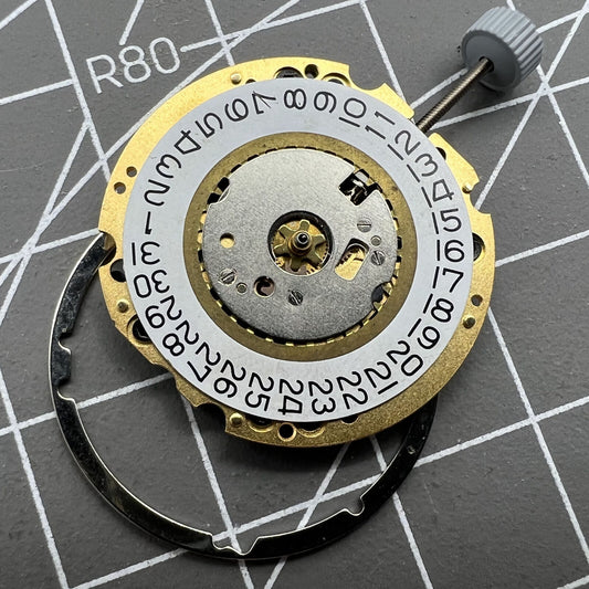 Ronda 705 golden quartz watch movement with date display at 3 o'clock, Swiss made precision.