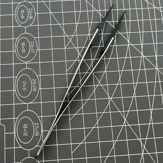 Stainless steel tweezers with carbon fiber tips for precise watch repair.