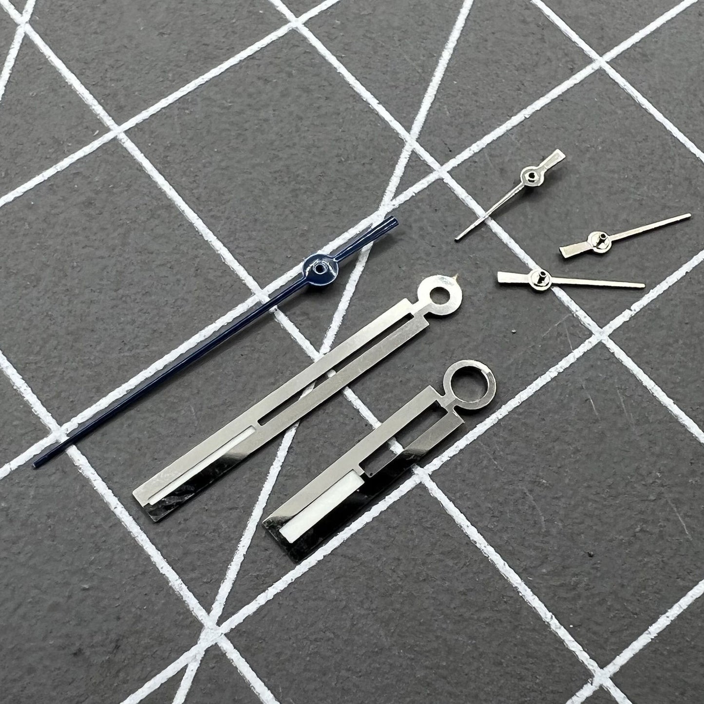 Silver luminous watch hands, compatible with Ronda 5021D quartz movement, ideal for low-light visibility.