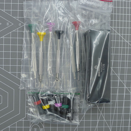 Swiss Bergeon 7778 watch screwdriver set with 6 precision blades, spare tips, and organizer stand for watch repair.