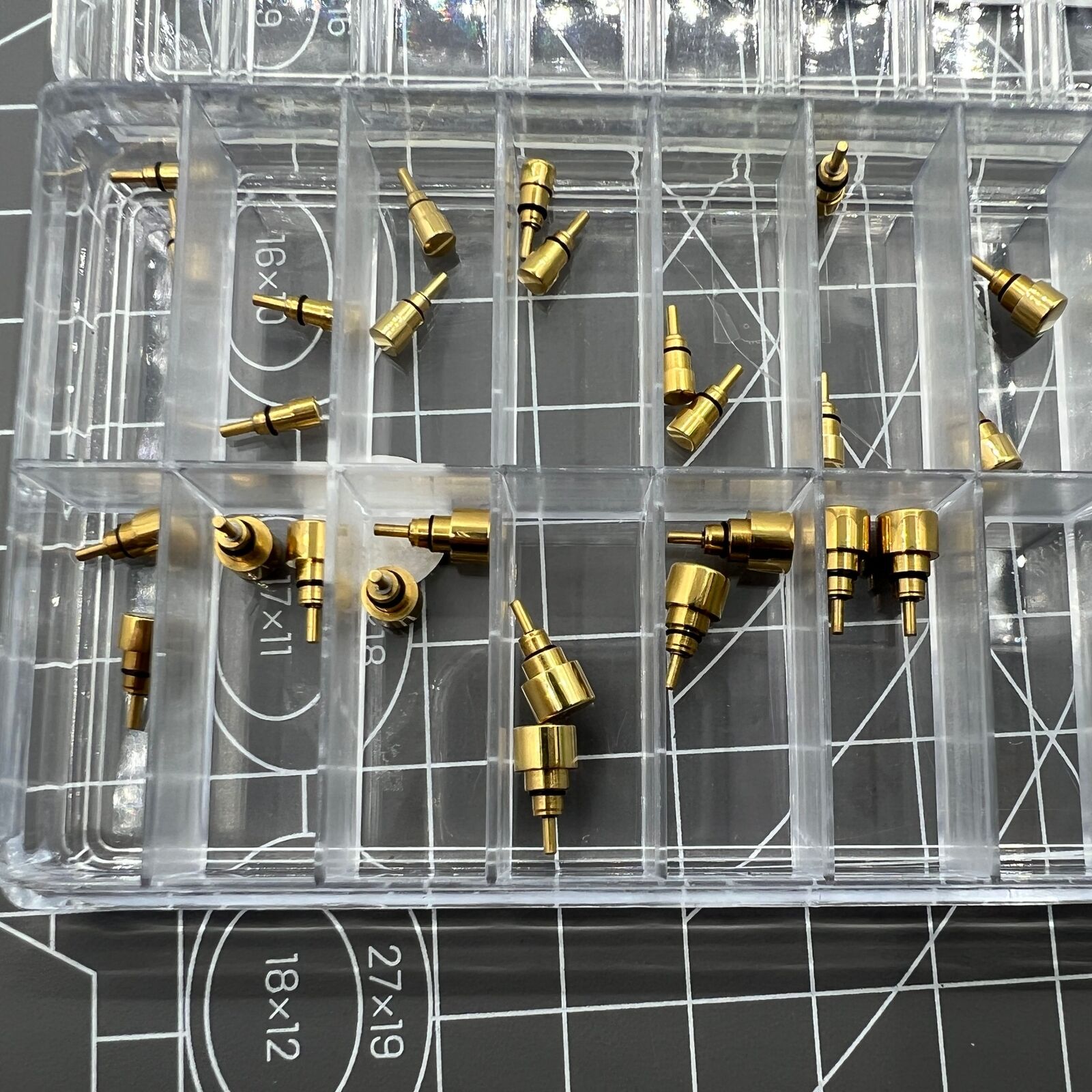 Set of 26 golden stainless steel watch pushers in 13 sizes, classic style for repairs and customization.