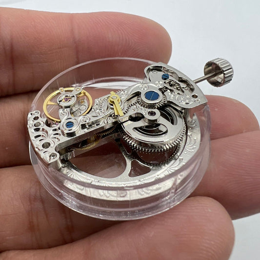 Silver long pendulum wheel watch accessory by Asian, automatic mechanical movement detail visible