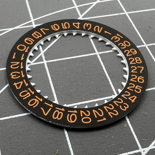Black background close-up of orange date wheel for NH35 NH36 watch movement by Seiko.