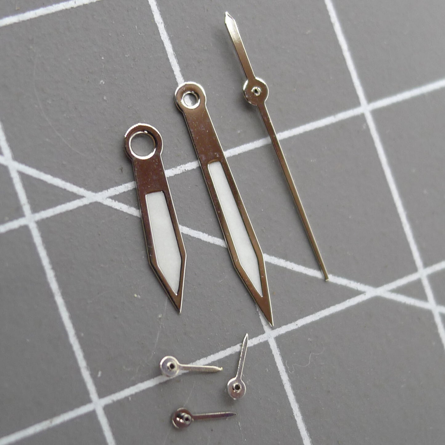 Green luminous 13mm pointed watch hands with silver trim for Miyota 0S10 movement, precise timekeeping accessory.