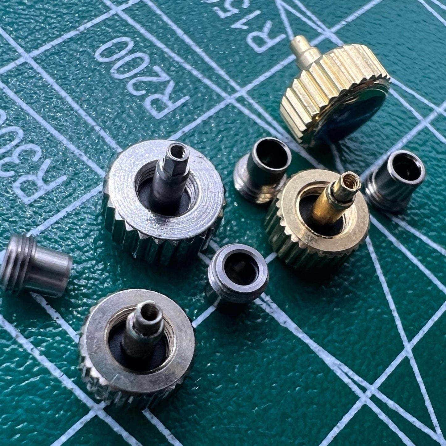 Stainless steel watch crown with silver and gold finish, screw-on tube and gasket by Durable brand.