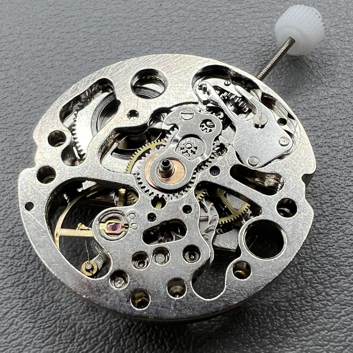 Hollow silver automatic watch movement revealing detailed mechanical gears and expert craftsmanship.