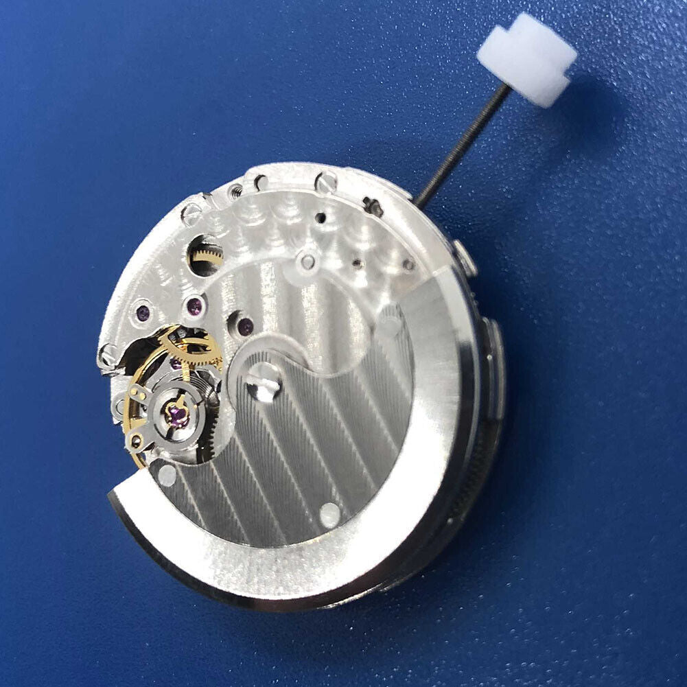 DG2813 automatic watch movement close-up with silver gears, date window at 3 o'clock.