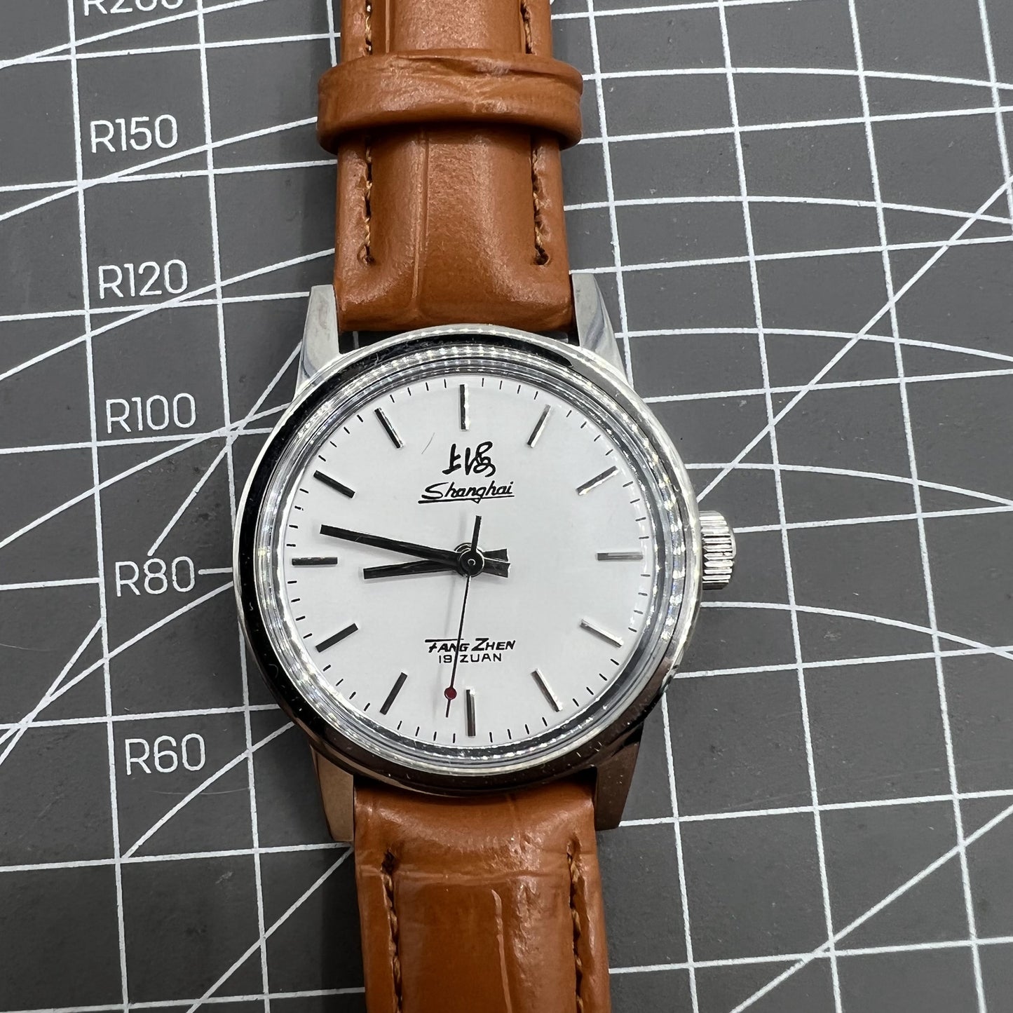 Silver 32mm Shanghai Factory manual mechanical watch featuring a silver case and nail markers for classic style.
