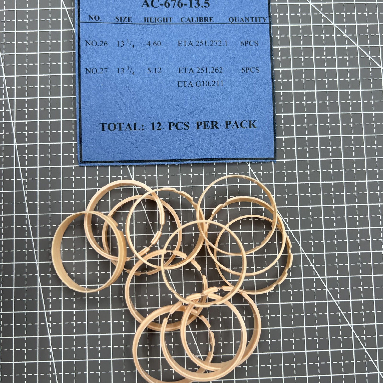 Set of 12 AC-676 brand 2-line 13.5mm movement case spacer rings for precise watch assembly.