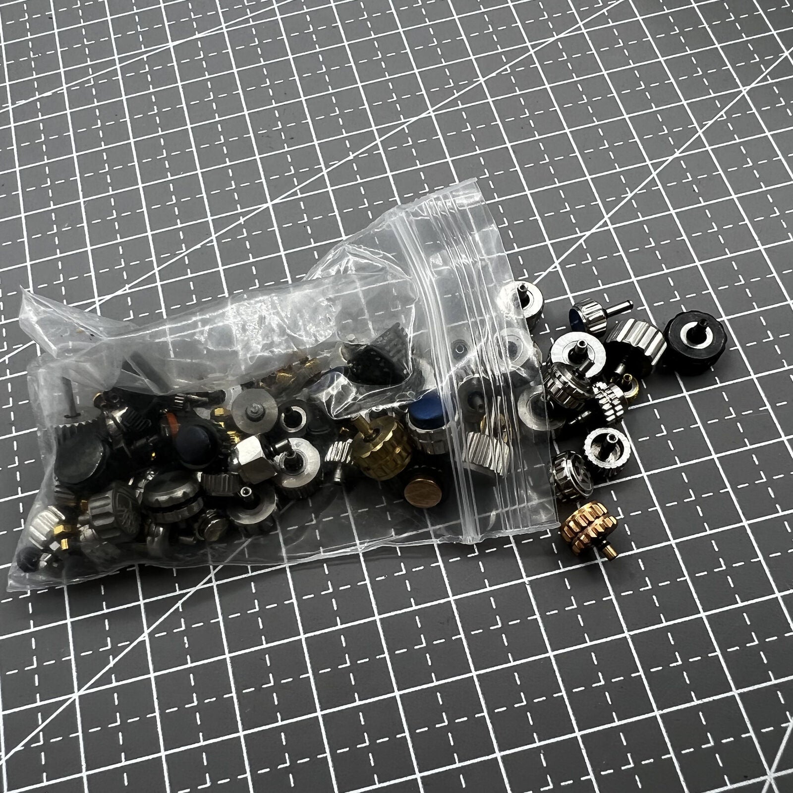 Assortment of 100 watch crowns in multiple sizes, perfect for watch repairs and replacements.