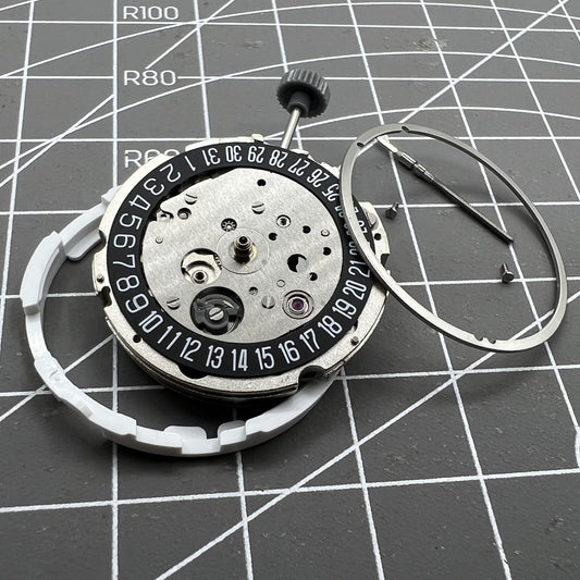 Miyota Citizen 8215 automatic watch movement with black dial and date at 6 o'clock, Japan-made.