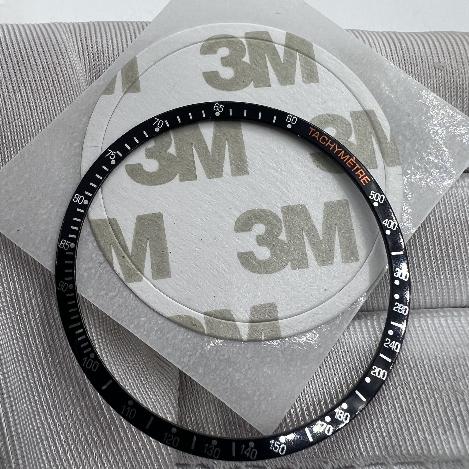 38.5mm black aluminum alloy bezel with white font, Omega Speedmaster accessory for watch customization.