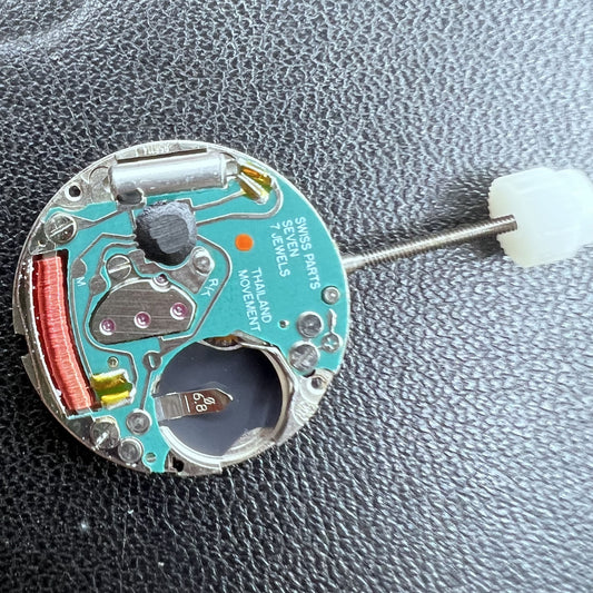 Swiss ETA 956.114 quartz watch movement with black disk, two hands, and gold date display at 6, precision timekeeping.