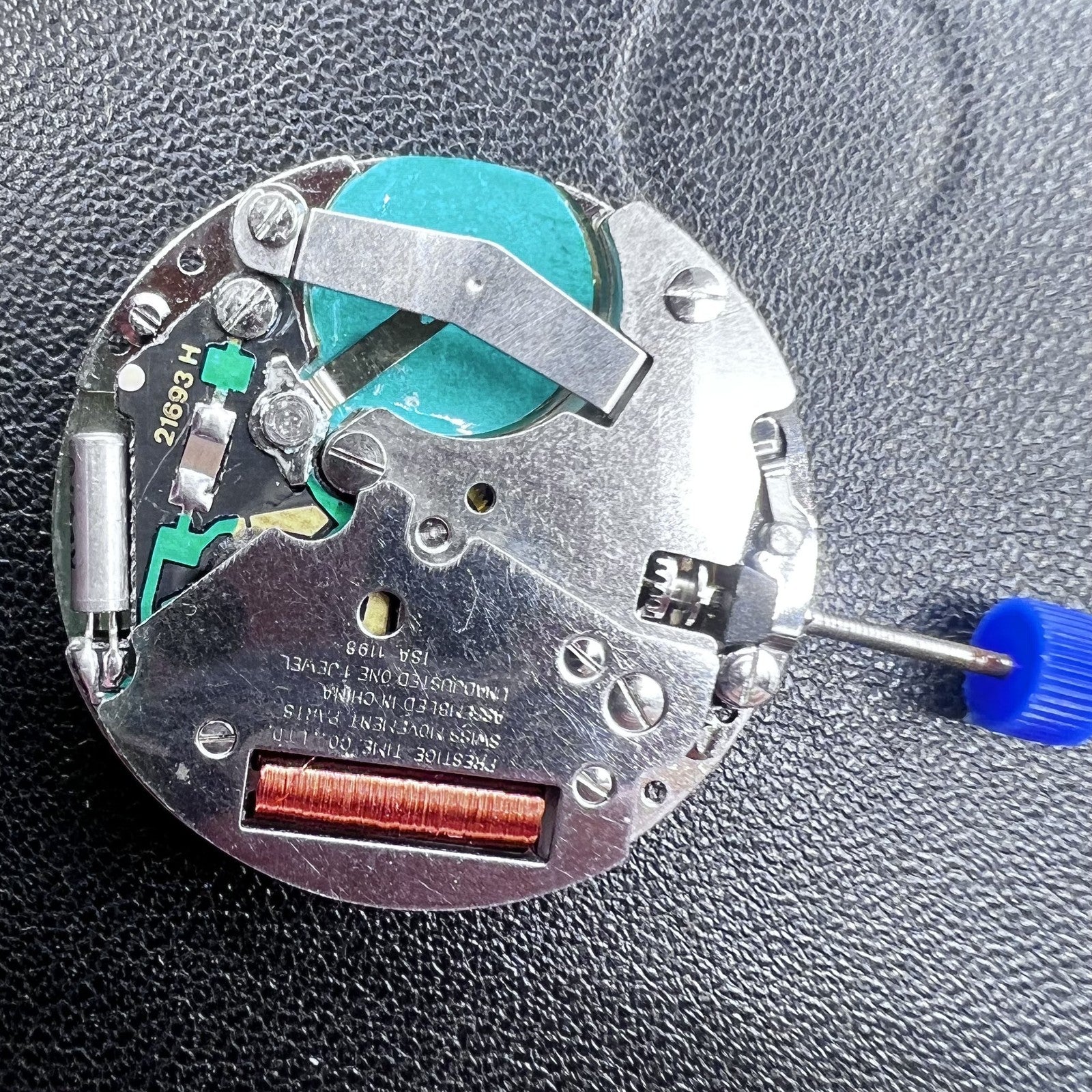 Swiss ISA 1198 Quartz watch movement with 3 hands, English day-date display for precision timekeeping.