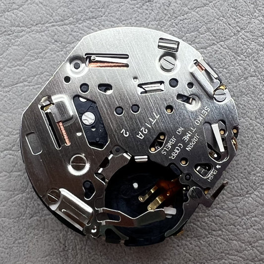 Seiko 7T12A quartz watch movement with single calendar and black disk, precise timekeeping.