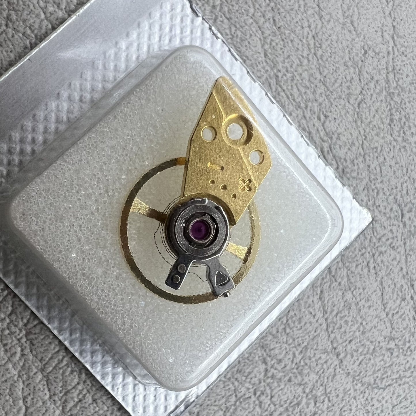 Golden balance wheel with splint for Miyota 8N24 movement, precision watch accessory by Miyota.