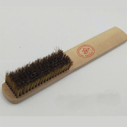 Copper brush with wooden handle for rust removal on metal, ideal for jewelry making and cleaning tasks.