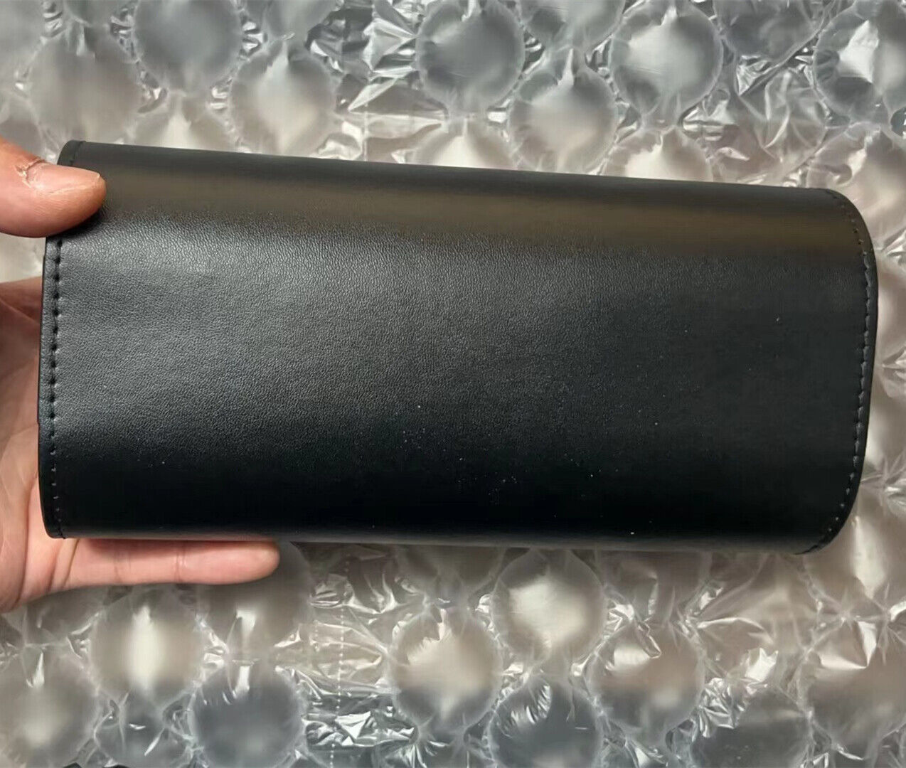 Black leather travel watch case, featuring 3 slots for secure, portable watch storage and organization.