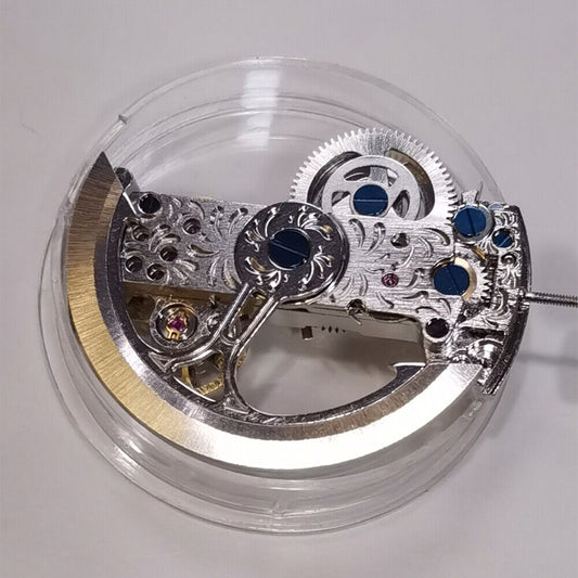 Rectangle auto chronograph watch movement showing balance wheel at 10 o'clock and rotor weight.