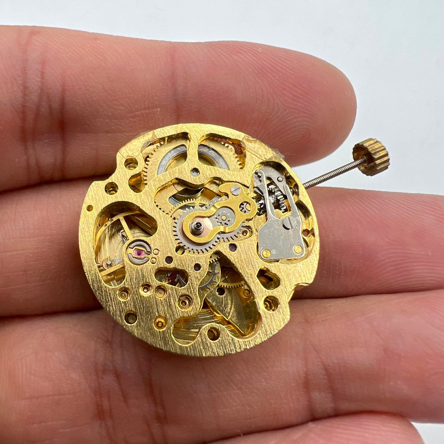 Golden hollow 26.5mm 7120 automatic mechanical watch movement, showcasing intricate gears and precision engineering.
