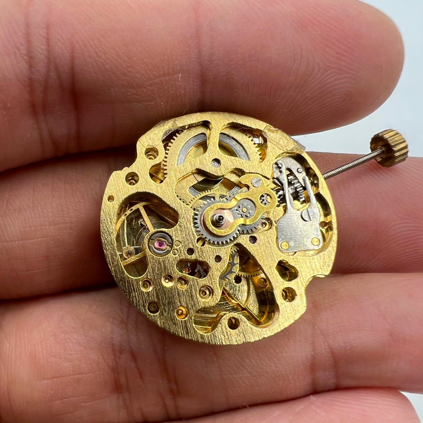 Golden hollow 26.5mm 7120 automatic watch movement with detailed gears and mechanical design.