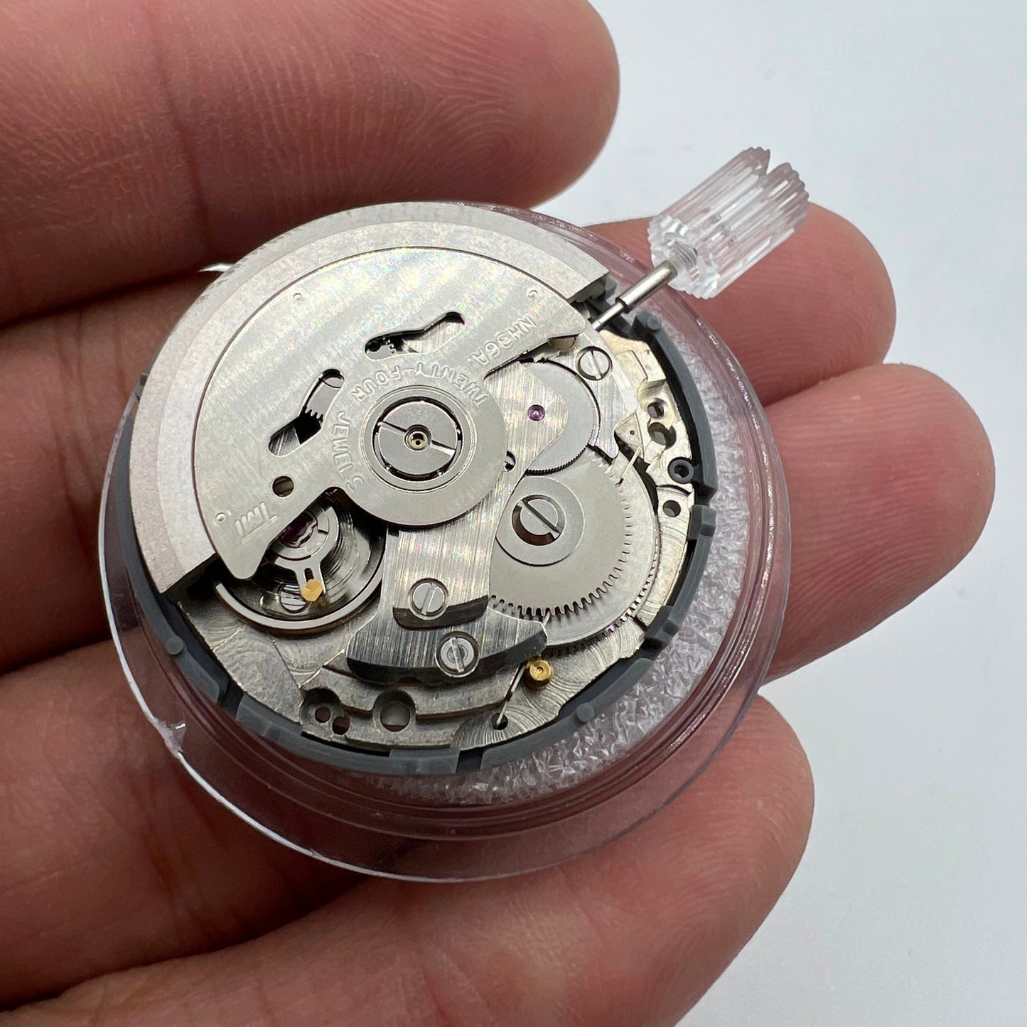 Miyota NH36A watch movement with black finish and green lume on dial, showcasing 3 crown positions for precise time setting.