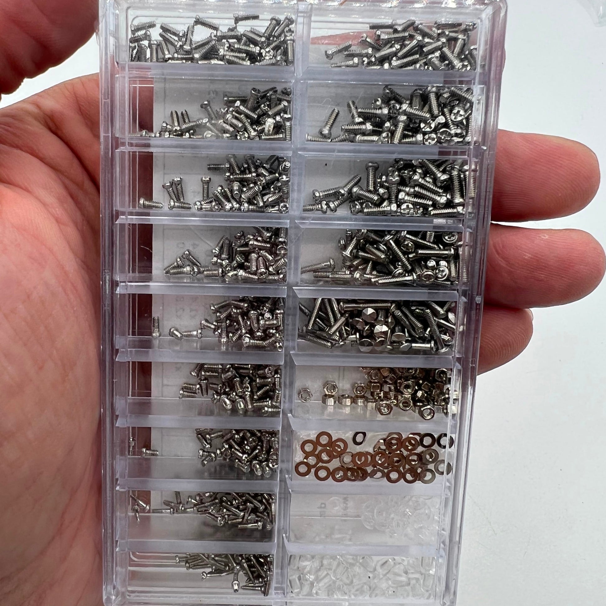 Assorted watch accessory screws and nuts set for precision micro repairs.