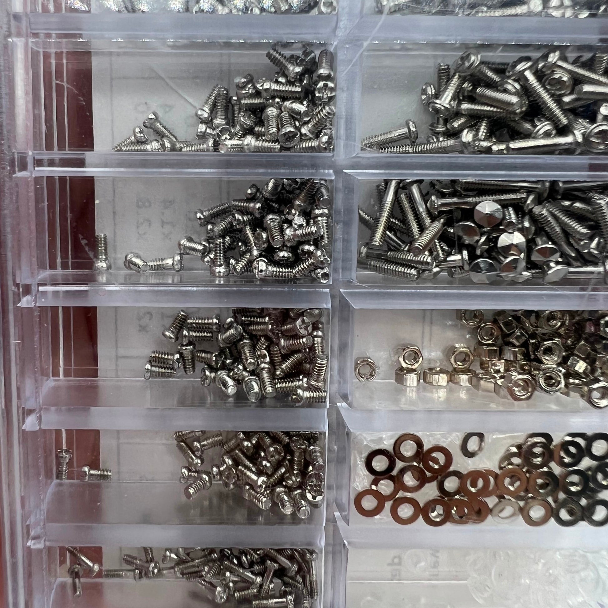 Assorted watch accessory screws and nuts set for precise micro watch repairs.
